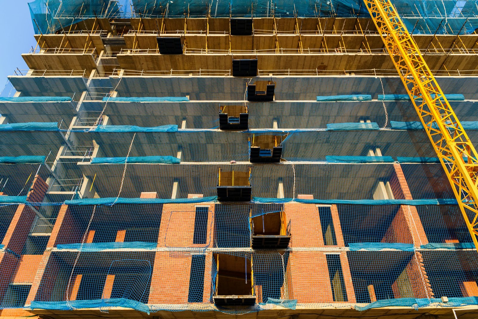 ellow crane on a construction site to lift large weights of construction material.